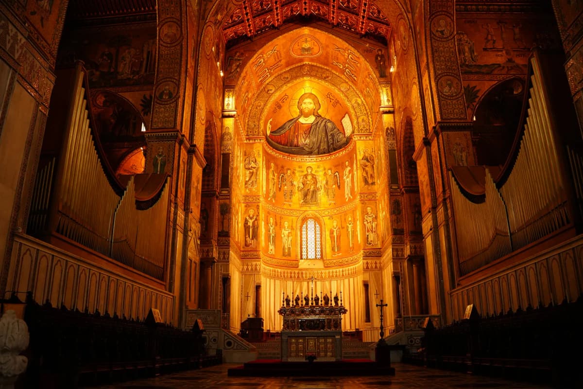 Interior view of the Monreale Cathedral showcasing its stunning Byzantine mosaics and grand organ pipes.